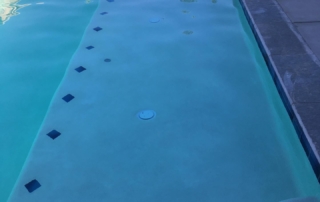 Finest Finish Sparkle Quartz White Pool ledge and step with blue tile detail