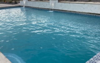 Sparkle Quartz Lakeside pool with decorative tile trim and white wall water feature
