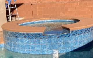 Sparkle Quartz tropical spa with water feature and blue tile and terracotta coping