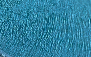 Finest Finish Sparkle Quartz Pacific pool with spa in backgrounFinest Finish Sparkle Quartz Pacific pool water