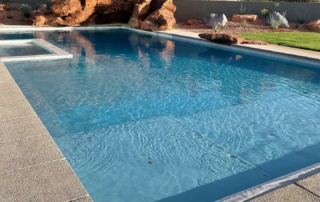 Finest Finish Sparkle Quartz Pacific pool with spa in backgrounFinest Finish Sparkle Quartz Pacific pool with spa boulder detail
