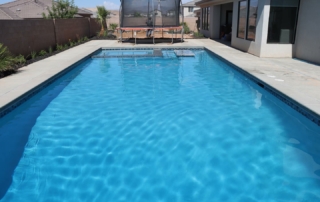 Finest Finish Sparkle Quartz Lakeside Pool edge with spa, in=pool table and bench. trampoline in background